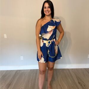 Palm Harbor Romper. One shoulder ruffle, floral print with romper with a belt.